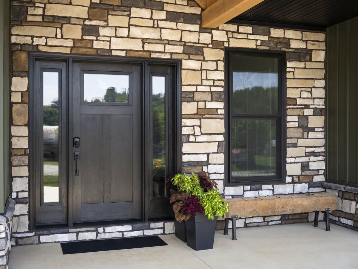 A ProVia Signet entry door and Endure windows on a stone and board and batten home
